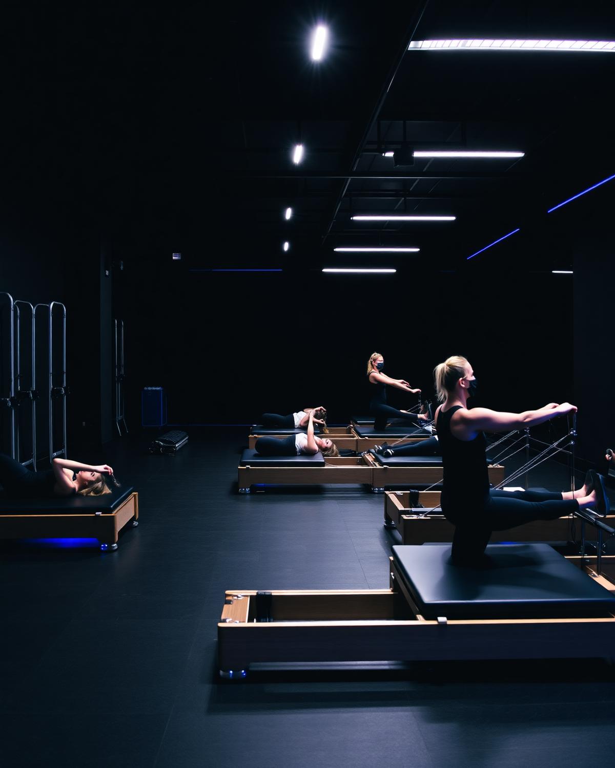 Group class on reformers in a dimly lit [solidcore] studio